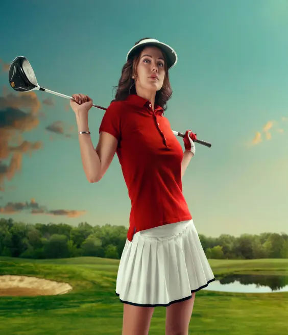 A woman in a red skirt and red shirt is holding a golf club.